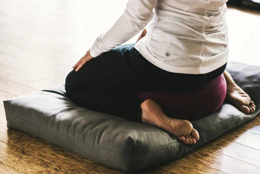 woman kneeling on meditation pillow